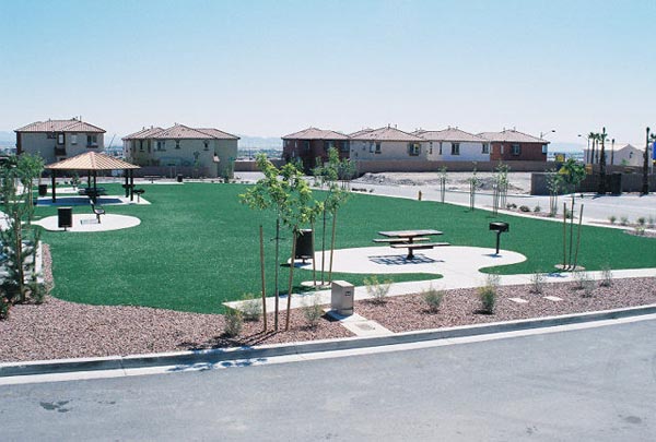 Fake grass installation at Southwest residential community park with gazebo, picnic tables, and desert gravel landscaping