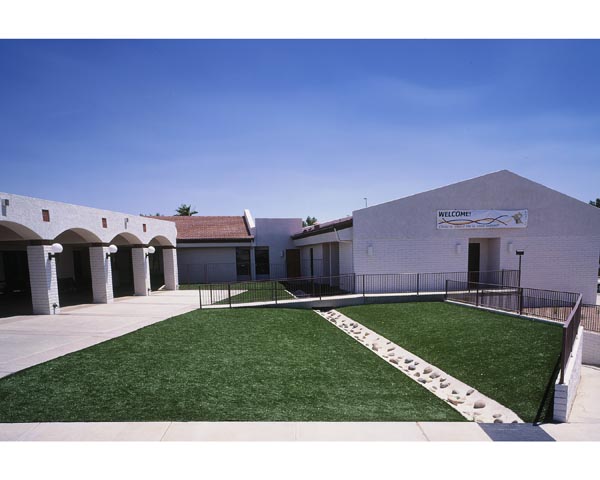 Best artificial lawn courtyard installation at Southwest-style school or community center with rock accent pathway