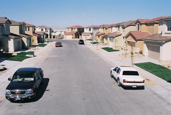 Best artificial lawns installed on front yards throughout suburban residential neighborhood street with Southwest-style homes