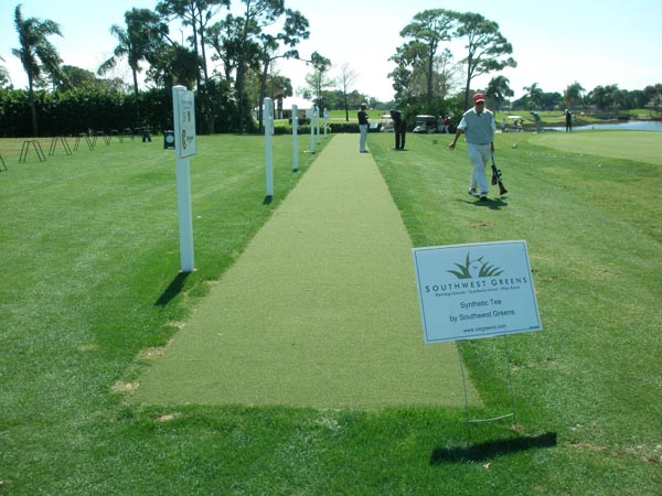 Southwest Greens synthetic tee lines installation demonstration at golf course driving range with players and signage