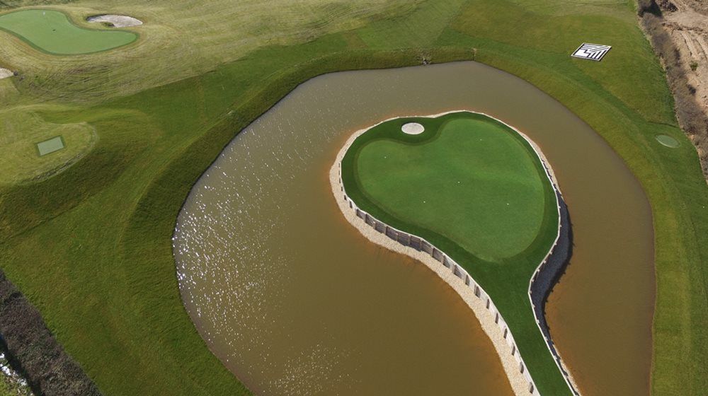 Albuquerque Aerial view of a vibrant green synthetic grass island in a natural pond on a golf course