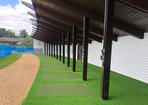 Albuquerque Covered outdoor tee line with light green synthetic grass boxes inside a dark green synthetic grass strip