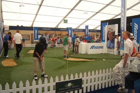 Indoor putting green with people testing it out at a putting event