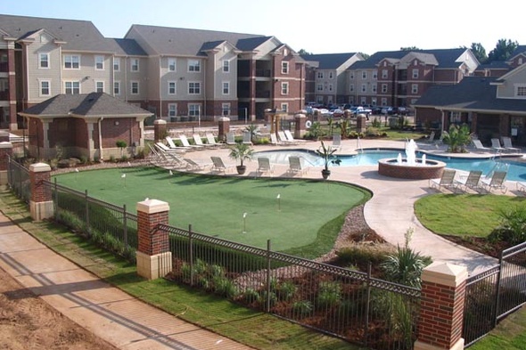 Artificial grass installed in a resort space with seating and a pool